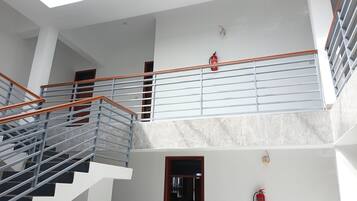 A multi-level interior with a staircase, metal railings, and a fire extinguisher.