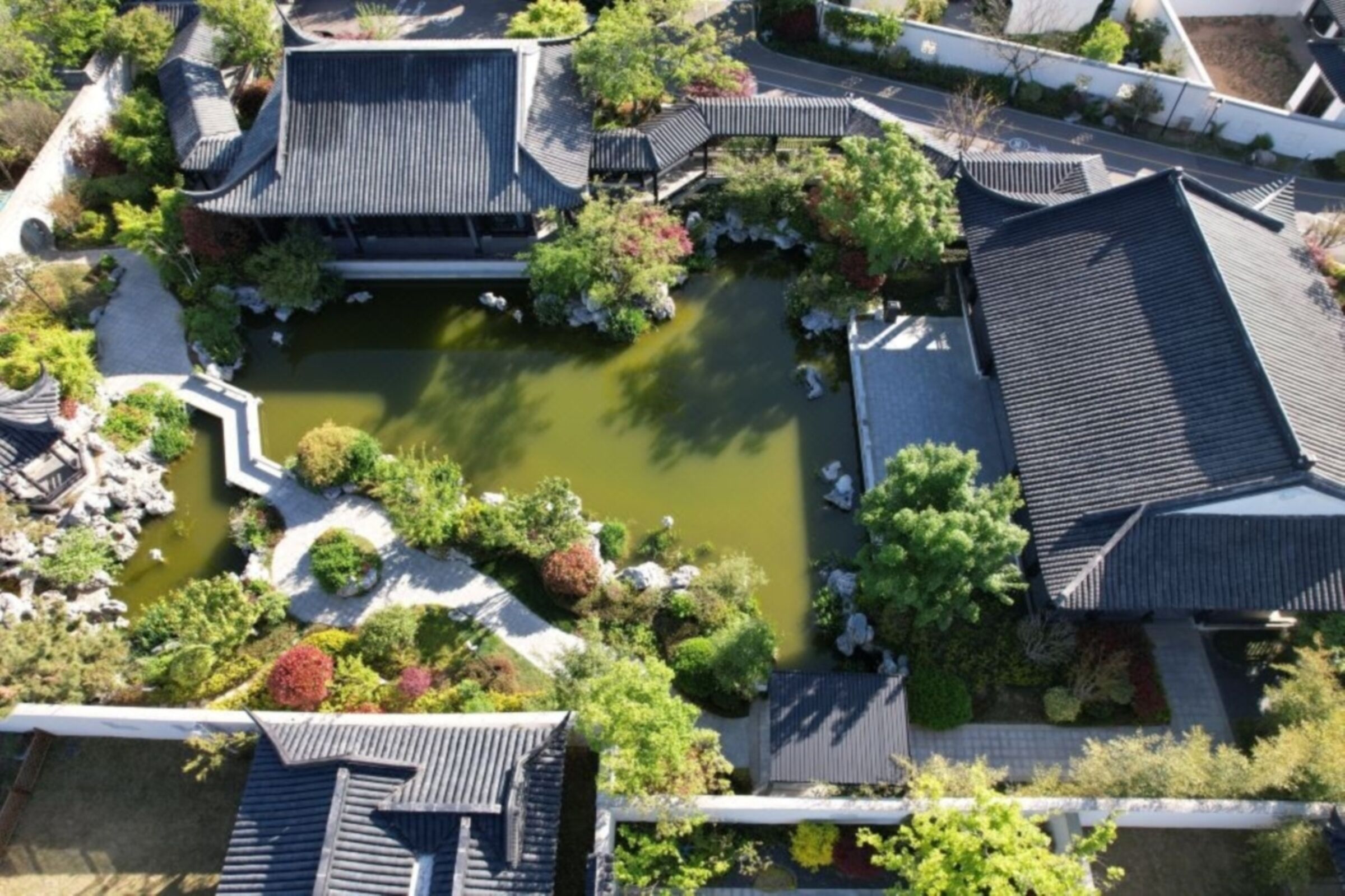 Vista aèria d'un conjunt d'edificis de tipus tradicional japonès, amb un estany central i vegetació circumdant.
