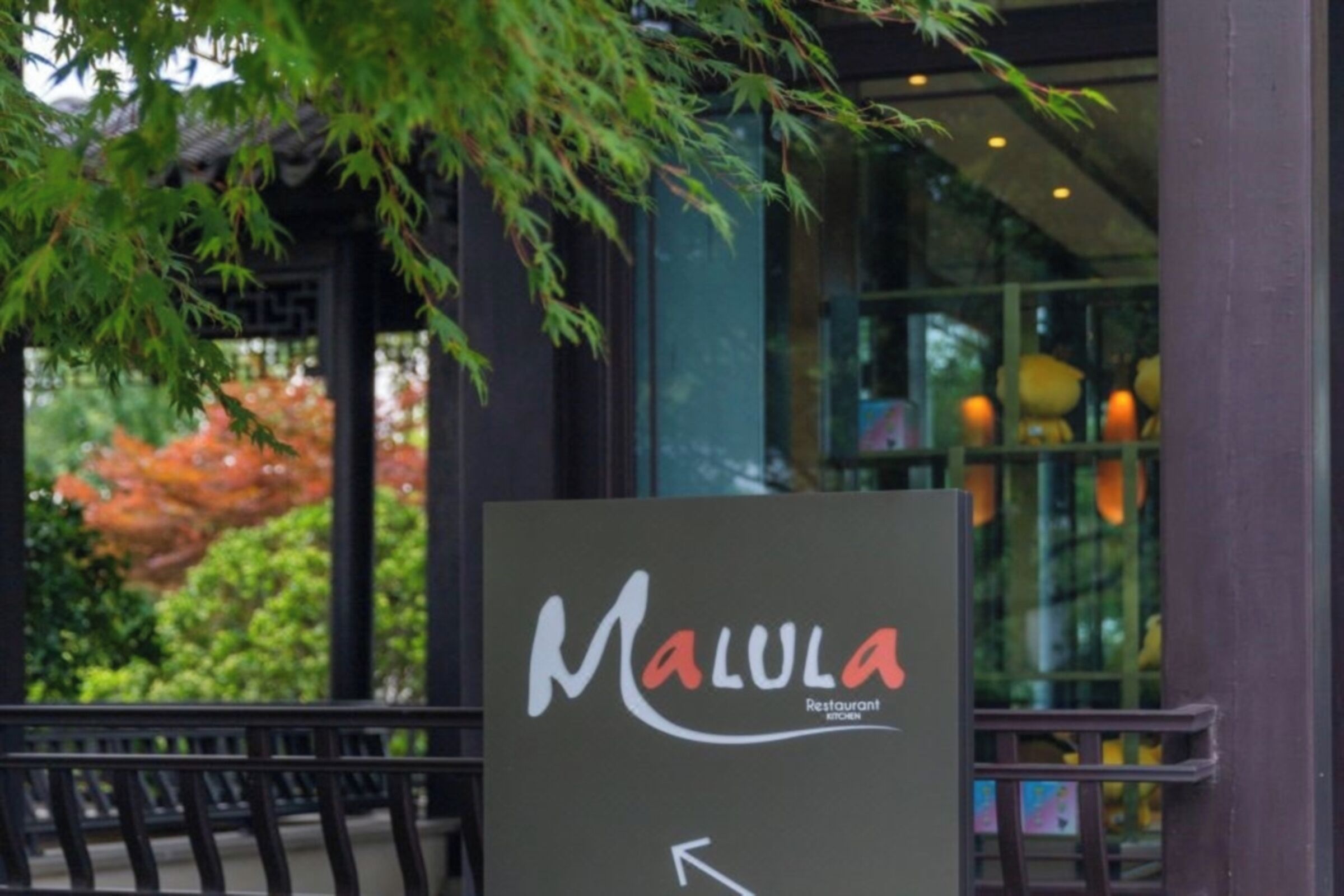 Une enseigne pour le restaurant Malula, avec une flèche indiquant la direction.