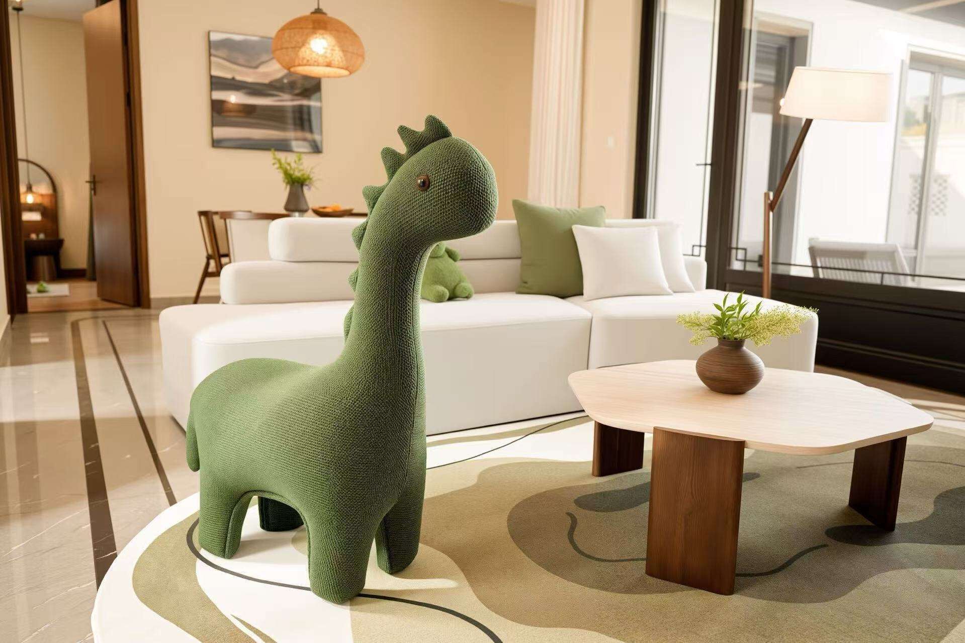 Una escultura de animal tejido en tono verde sobre una plataforma circular en un salón moderno con un sofá blanco y una pequeña mesa con un jarrón.