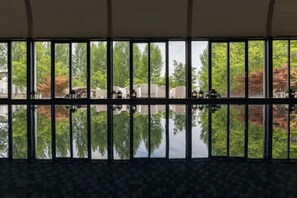 A room with large windows reflecting trees and a building outside. - Canbeauty Golf Resort and SPA Weihai (Weihai)