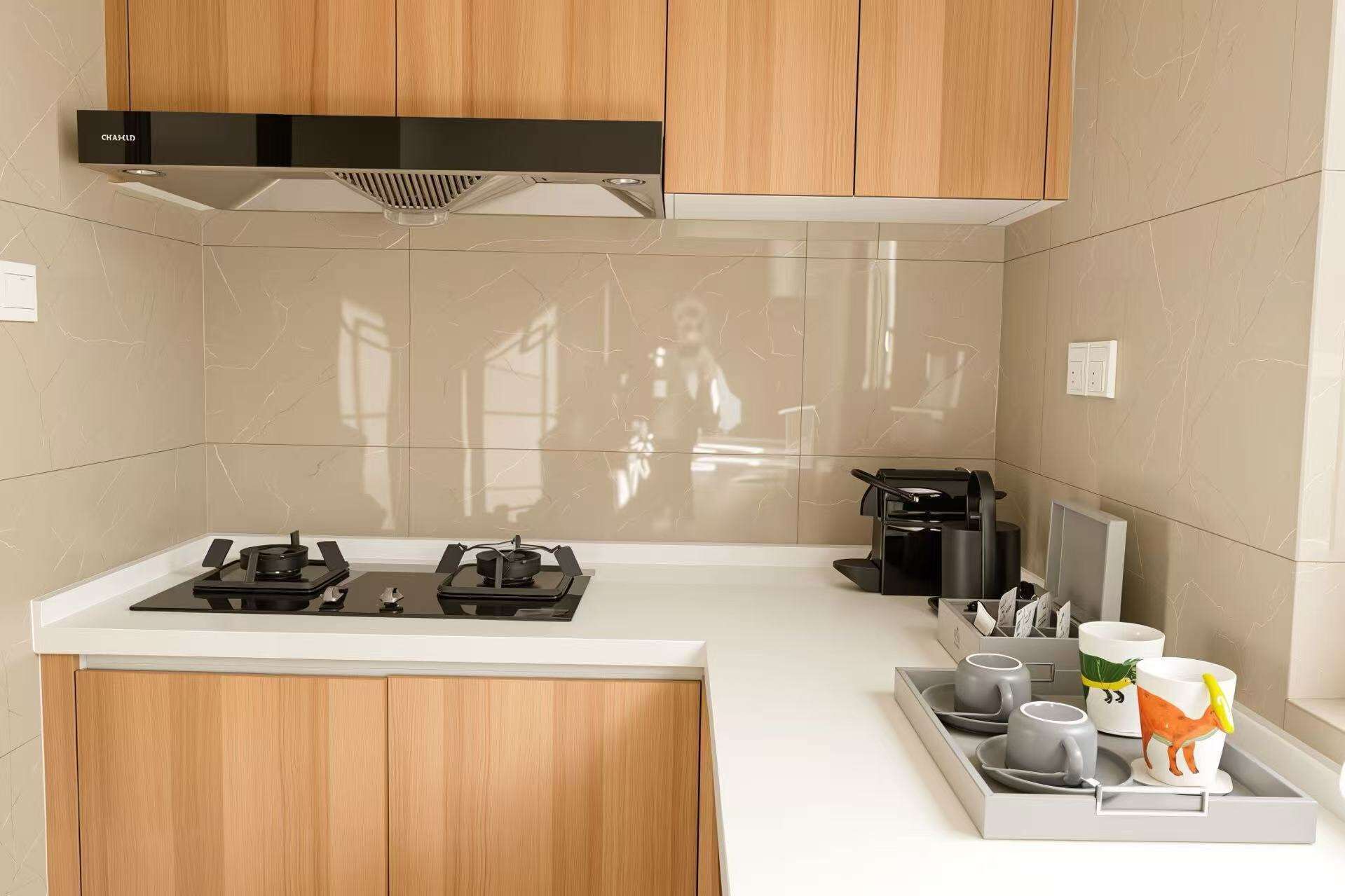 Una cocina moderna con estufa a gas, cafetera y una bandeja con tazas y una taza.