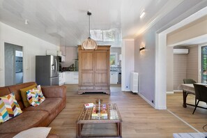A modern living room with a sofa, coffee table, and wooden cabinet.