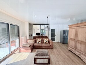 A spacious living room with a sectional sofa, a wooden coffee table, and a large cabinet.