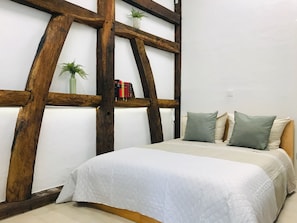 A bedroom with a bed, pillows, a bookshelf, and a plant. - Private Apartment—Near Strasbourg—Baden-Baden (Rheinau)