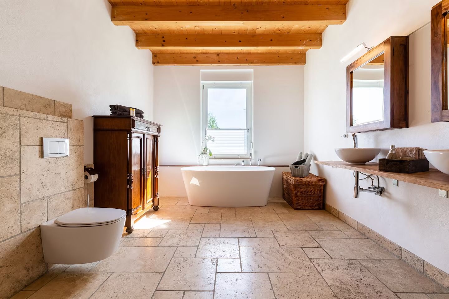 Une salle de bain avec une baignoire sur pieds, un meuble en bois et un grand miroir au-dessus du lavabo.