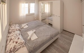 A bedroom with a bed, a wardrobe, a mirror, and a window. - Nice apartment in Jesenice with lake view (Jesenice)