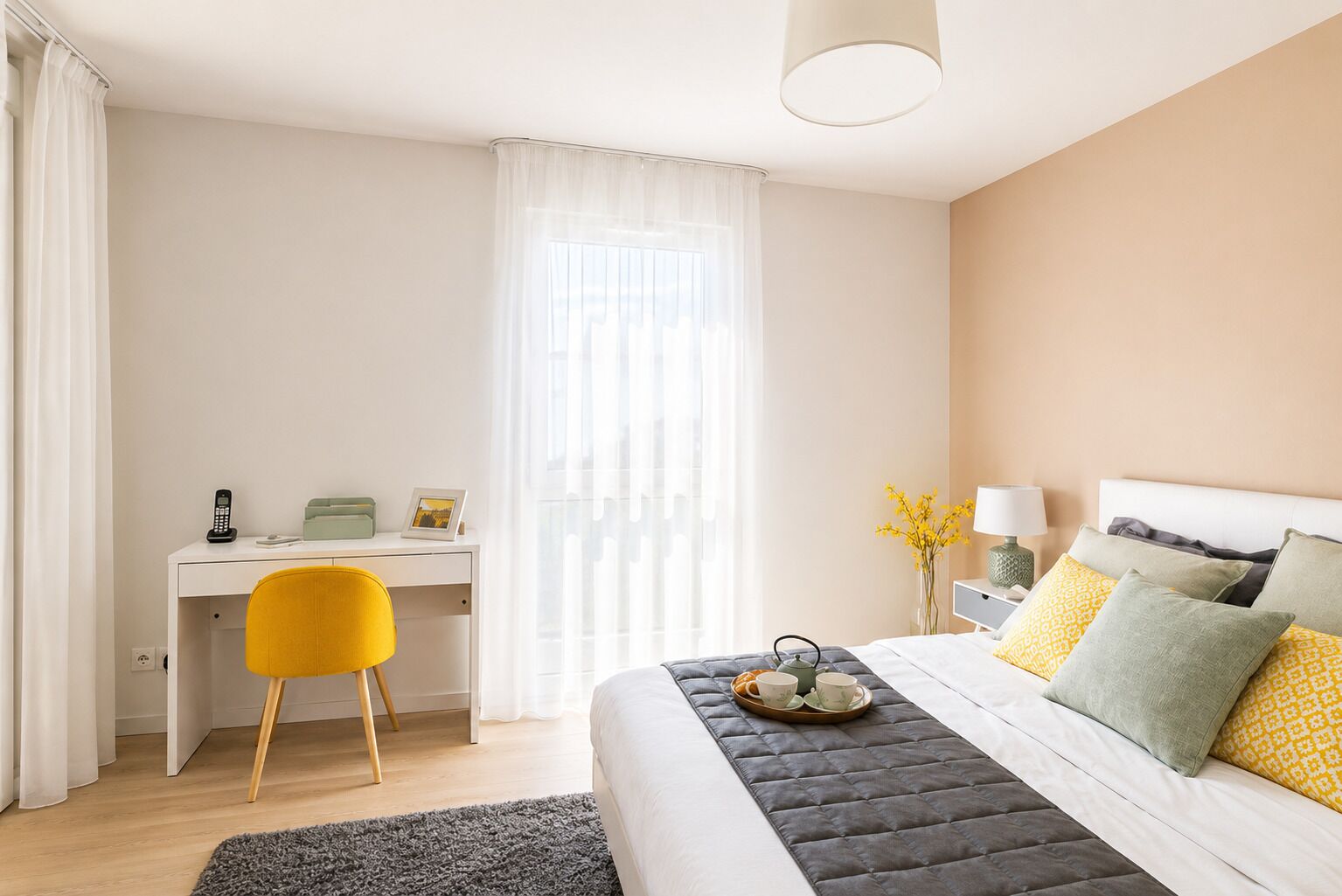 Une chambre d’hôtel comprenant un lit, un bureau, une chaise et une table de chevet avec une lampe.