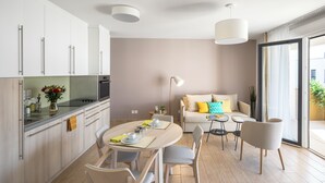 Ett modernt kök med en matplats, en soffa och ett bord dukat för två personer.