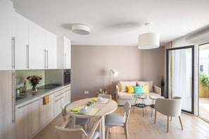 Una cocina moderna con comedor, un sofá y una mesa dispuesta para dos.