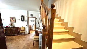A staircase with wooden balusters and a handrail, leading to a landing with a radiator and a chair. - SUN HOUSE MONTORSO-OASIS OF RELAXATION A STONE'S THROW FROM THE SEA (LORETO)