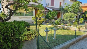 A residential area with a fenced garden, a stone fountain, and a building with a tiled roof. - SUN HOUSE MONTORSO-OASIS OF RELAXATION A STONE'S THROW FROM THE SEA (LORETO)