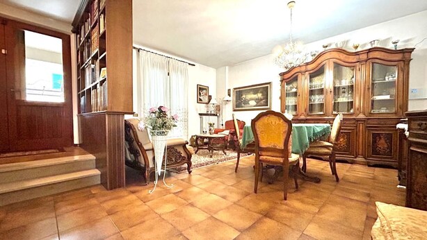 A spacious living room with a wooden staircase, a dining area with a green tablecloth, and a large wooden cabinet. - SUN HOUSE MONTORSO-OASIS OF RELAXATION A STONE'S THROW FROM THE SEA (LORETO)