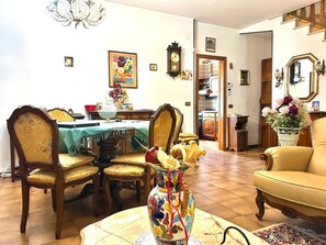 A dining area with a table, chairs, and a vase with flowers. - SUN HOUSE MONTORSO-OASIS OF RELAXATION A STONE'S THROW FROM THE SEA (LORETO)