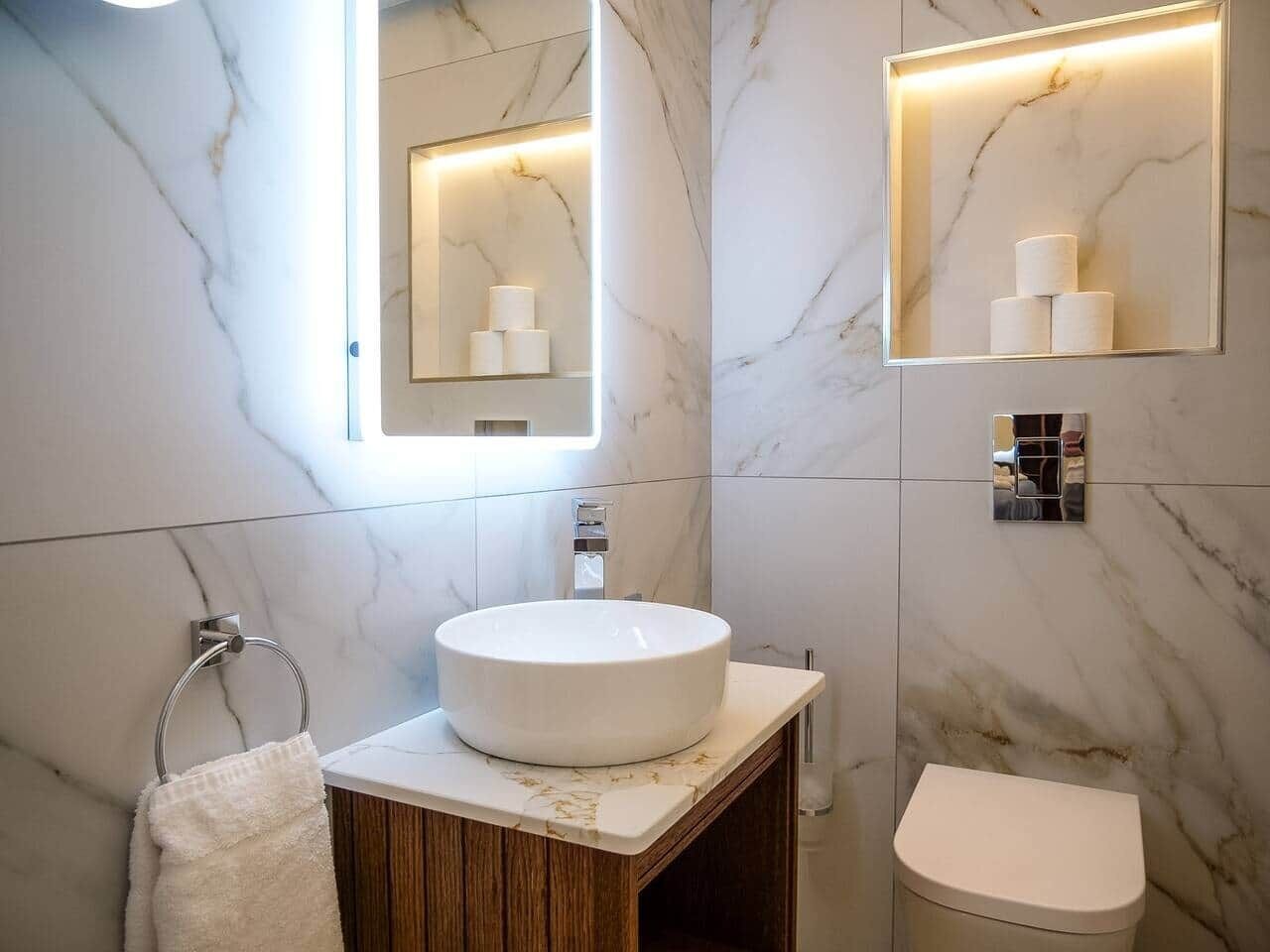 A bathroom with a round sink, a mirror, and a toilet.