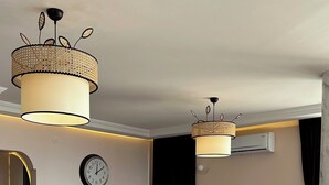 A modern living room with a sofa, a dining area with a table set, and a large clock on the wall. - Serene Stylish Central Cihangir Flat w/ Bosphorus 3-bedroom apartment (Beyoglu)