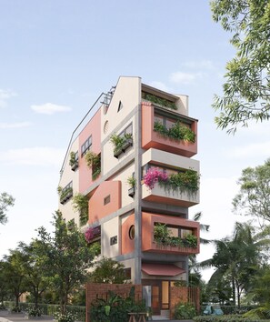 A multi-story building with balconies, a brick base, and a flat roof. - Cocoon Danang Airport Hotel & Apartment (Hoa Cuong)
