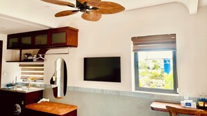 Eine kleine Küche mit Deckenventilator, einem Fernseher und einem Fenster mit Blick.