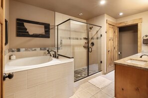 Ein modernes Badezimmer mit einer großen Badewanne, einer Duschkabine und Holzschränken.