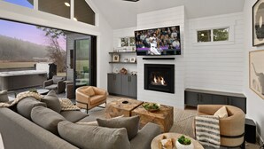 A modern living room with a fireplace, a television, and a sofa. - Apres Chalet in Roslyn (Cle Elum)