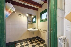 A bathroom with a checkered floor, a sink, a mirror, and a radiator.