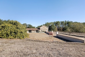 A building with a stone facade, a fenced area, and a clear sky.
