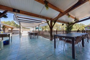 An outdoor patio with a covered seating area, tables, and chairs. - Country house 'Seul Au Monde' with private pool, terrace and private garden (Guizengeard)