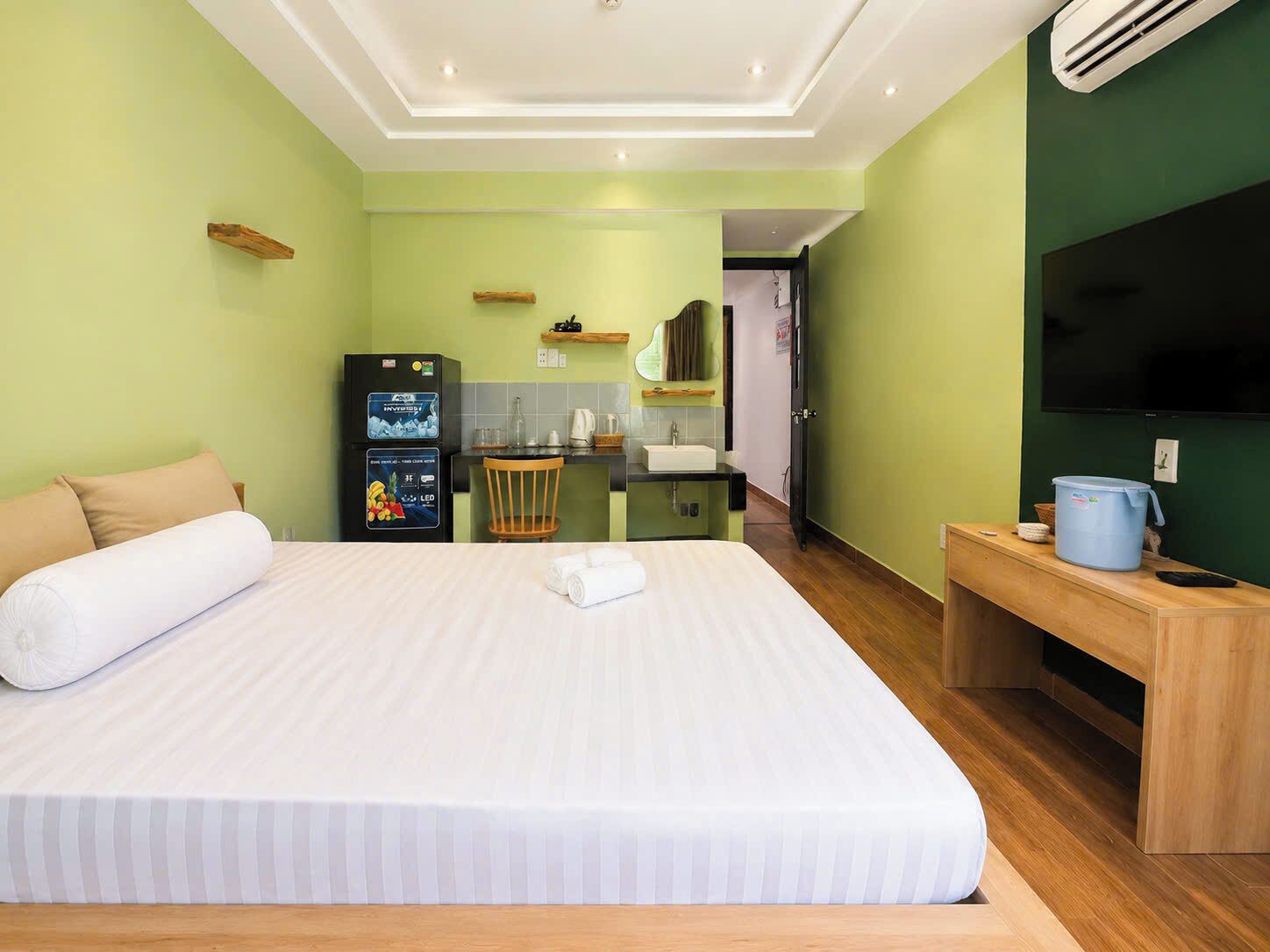 Une chambre d’hôtel équipée d’un lit, d’un bureau, d’une kitchenette et d’un téléviseur.