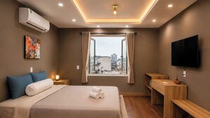 A modern hotel room with a bed, bedside tables, a TV, and a window with a city view. - Ben Thanh Hideaway - A Cozi Stay  (Ho Chi Minh City)