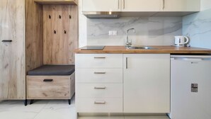 Eine moderne Küche mit Holzausstattung, einem eingebauten Geschirrspüler und einer Marmor-Spritzschutzwand.