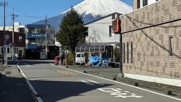 Una calle con una señal de tráfico, edificios y una montaña al fondo.