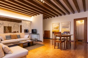 Ein modernes Wohnzimmer mit Sofa, Couchtisch und Esstisch.