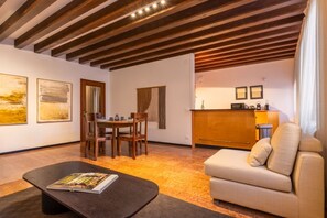 A modern living room with a wooden ceiling, a dining area, a sofa, and a kitchen area. - Welcome to Squero Home, a welcoming and refined residence in the heart of Venice, just behind Piazza San Marco and facing on the famous Calle with boutiques and designer labels.Located on the second floor of a building with an elevator, this apartment co (Venice)
