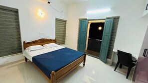 Ein Schlafzimmer mit einem Bett, einem Sessel und einem Kleiderschrank.