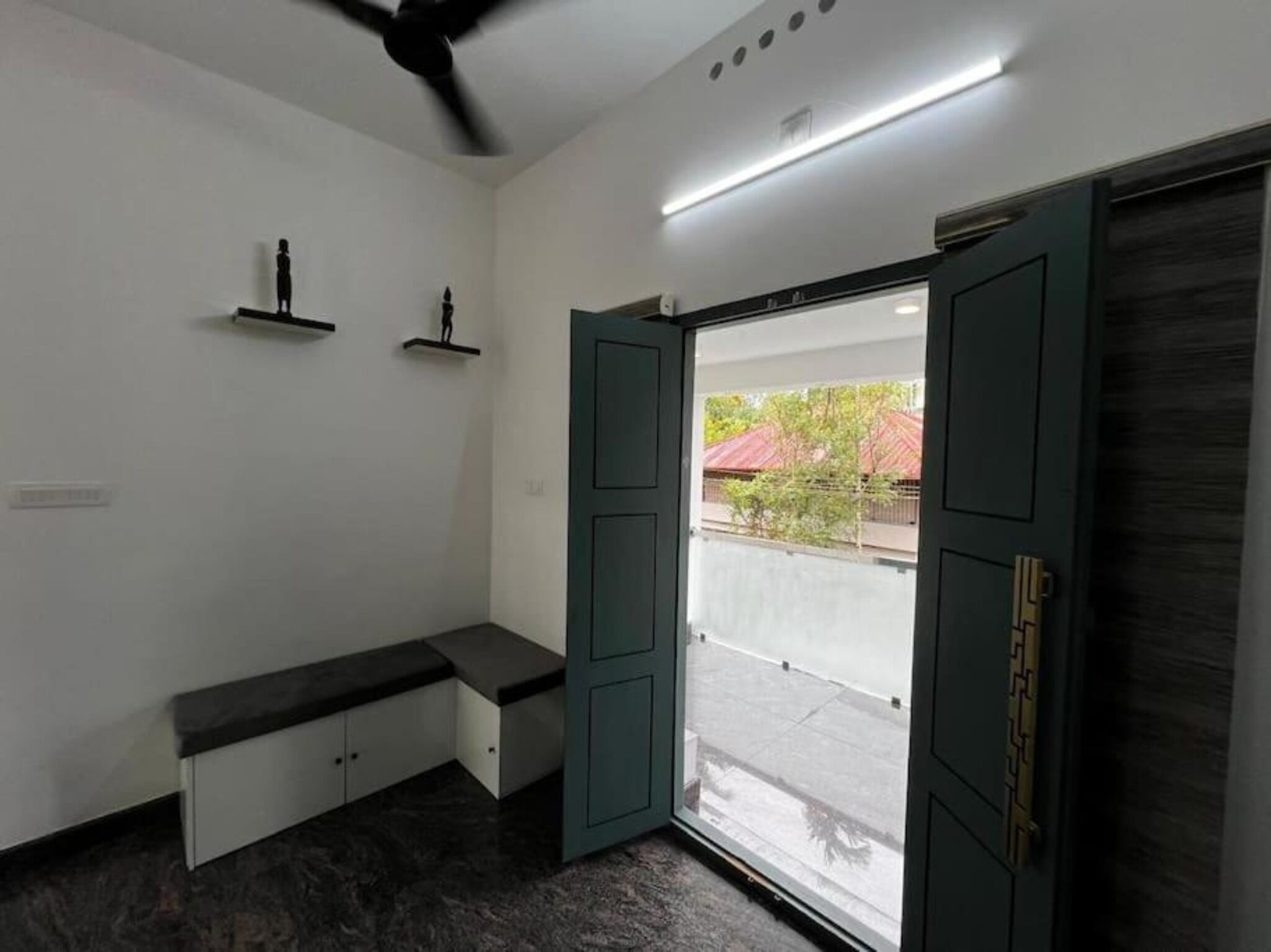 A room with a bench, a ceiling fan, a door with a view, and a ceiling light.