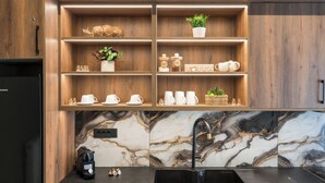 Ett kök med träskåp, en backsplash i marmor och en svart diskho.
