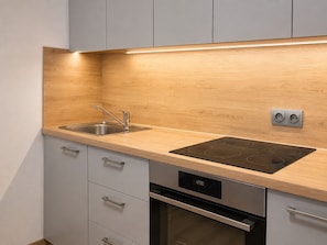Una cocina con un lavamanos doble, una estufa integrada y un lavavajillas.