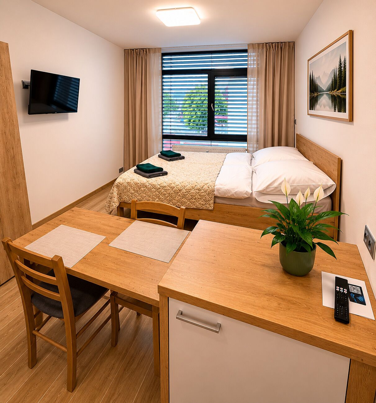 Une chambre d’hôtel comprenant un lit, un bureau avec une chaise, une télévision, une fenêtre avec des rideaux et un tableau au mur.