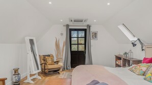 Une chambre à coucher avec un lit, un bureau, une chaise, une fenêtre et une porte.