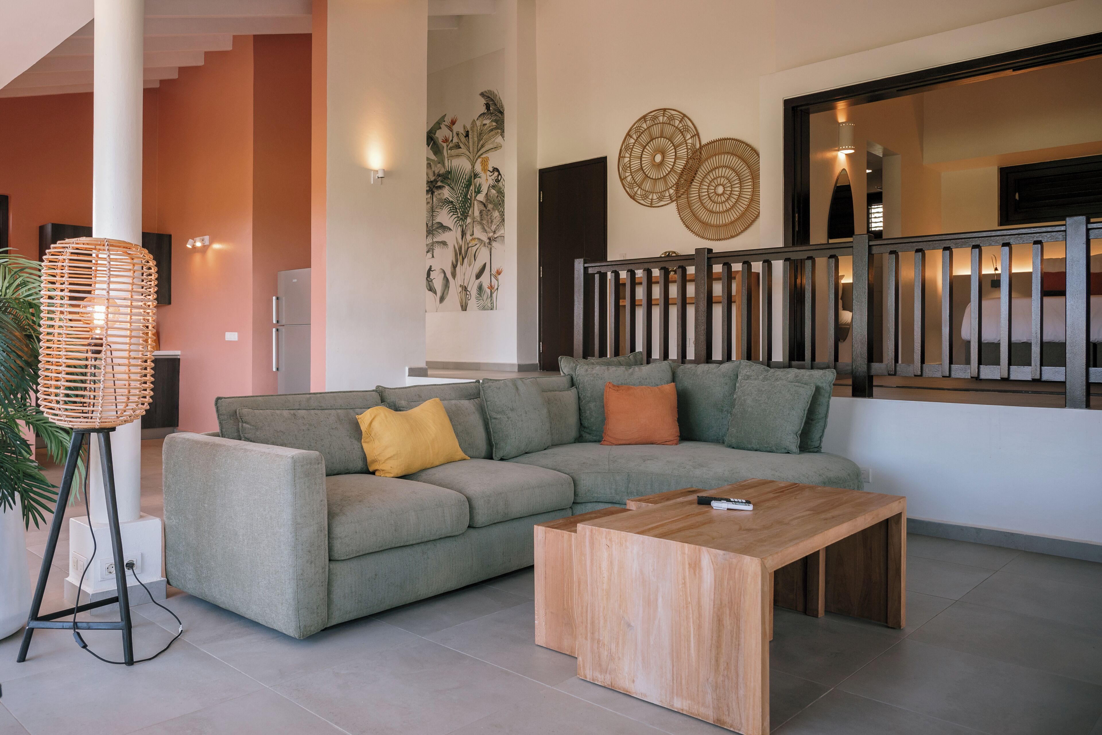 A modern living room with a grey sofa, wooden coffee table, and a large woven floor lamp.