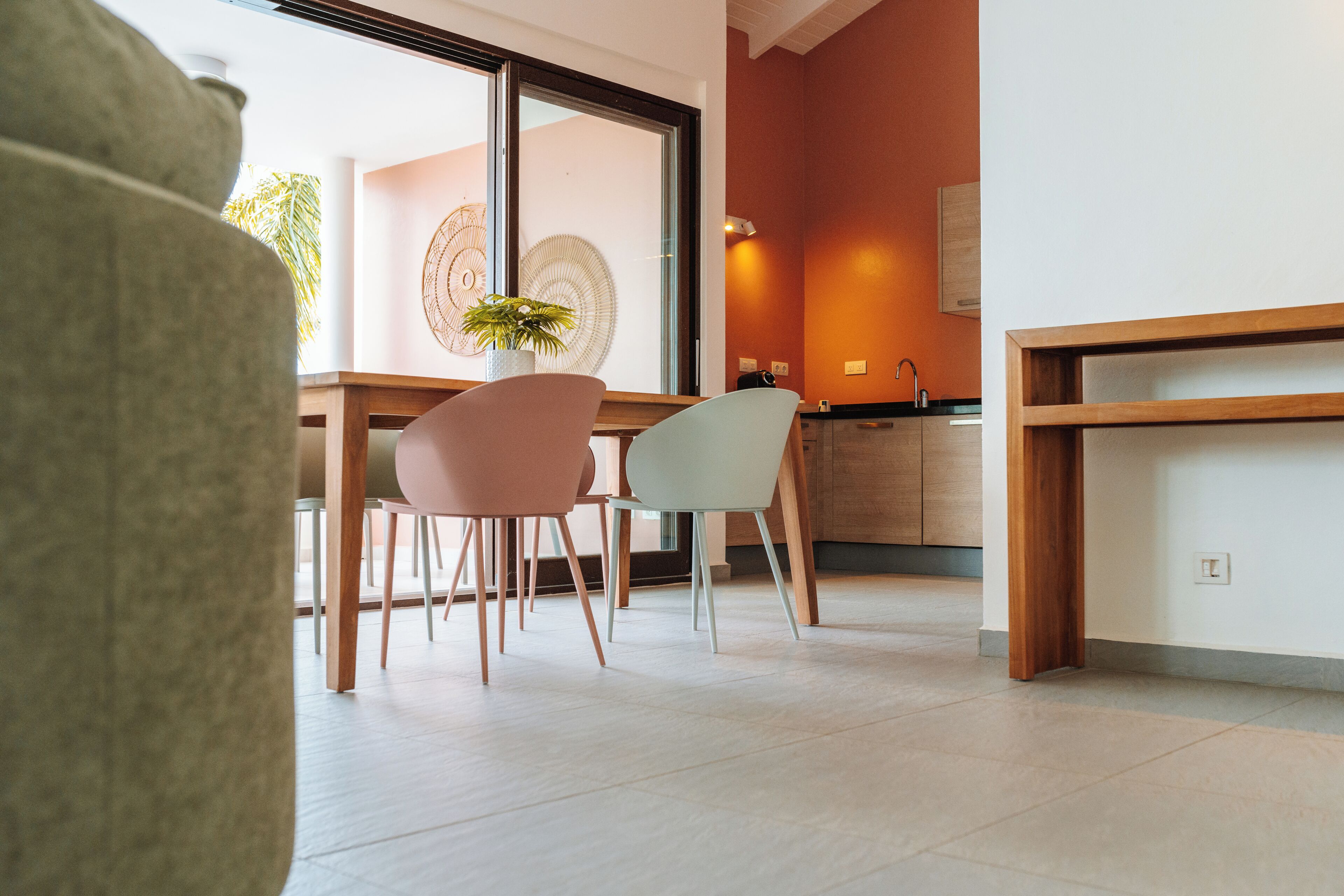 A modern interior with a dining area, a kitchen, and a large window.