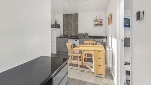 Een kleine keuken met een eethoek, een wasmachine en een radiator.