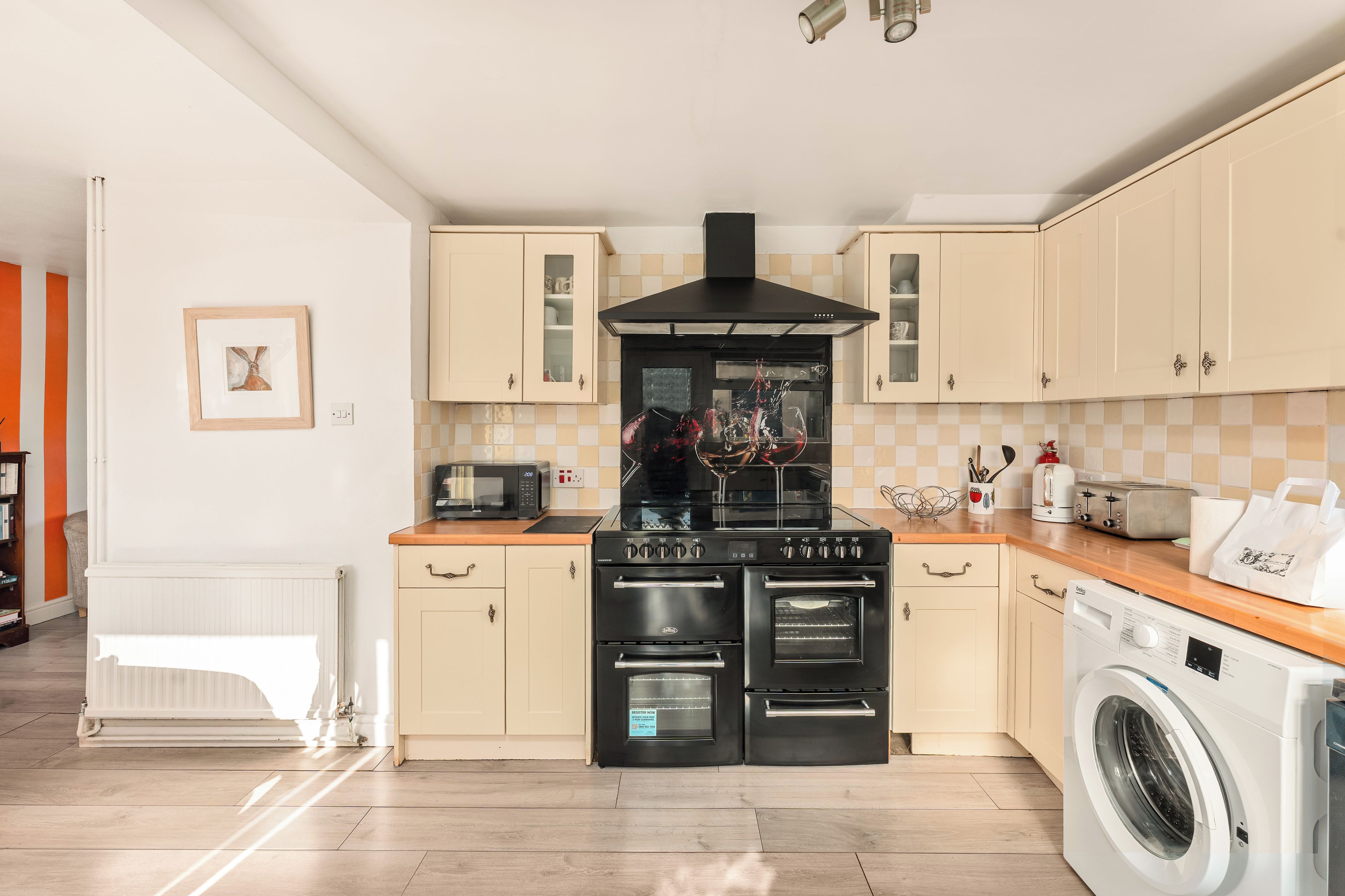 A modern kitchen with a built-in oven, microwave, and a washing machine.