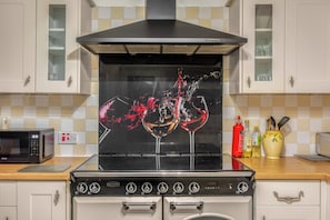 Una cucina con fornello, forno a microonde e mobili.
