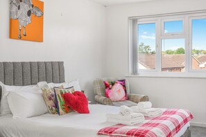 A bedroom with a bed, pillows, a chair, a window, and a painting on the wall. - Badger Haven Apt 1  - Self contained apartment in Brackley (Brackley)