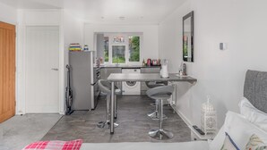 Una cocina compacta con comedor, lavadora y un pequeño espacio bar.