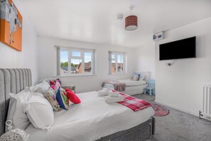 A modern bedroom with two beds, a flat-screen TV, and large windows. - Badger Haven Apt 1  - Self contained apartment in Brackley (Brackley)