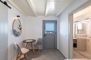 Ein Zimmer mit Blick, eine Tür, ein Tisch, zwei Stühle und eine dekorative Wandgestaltung.