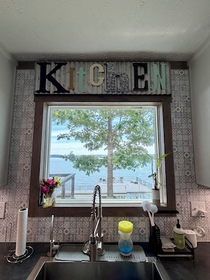 A kitchen with a window view, a sink, and a 'KITCHEN' sign above the window. - 4 Bedroom, 2 Bath, Located on Main Lake, with Boathouse, Boat Slips, Sleeps 11 (Henrico)
