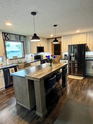 A modern kitchen with a large island, pendant lights, stainless steel appliances, and a view of the outdoors. - 4 Bedroom, 2 Bath, Located on Main Lake, with Boathouse, Boat Slips, Sleeps 11 (Henrico)